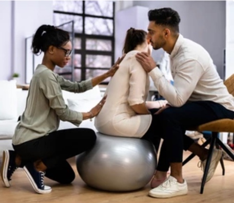 Woman in first stages of Labour with her Doula and Partner